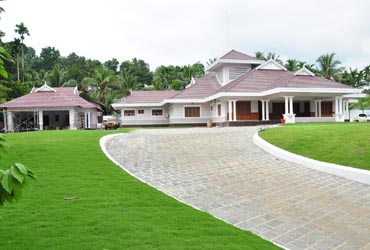 Happy carpenter sitting on the the roof beams and hammering a large nail